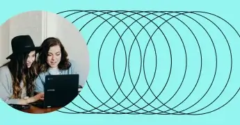 Two people collaborating while looking at a laptop